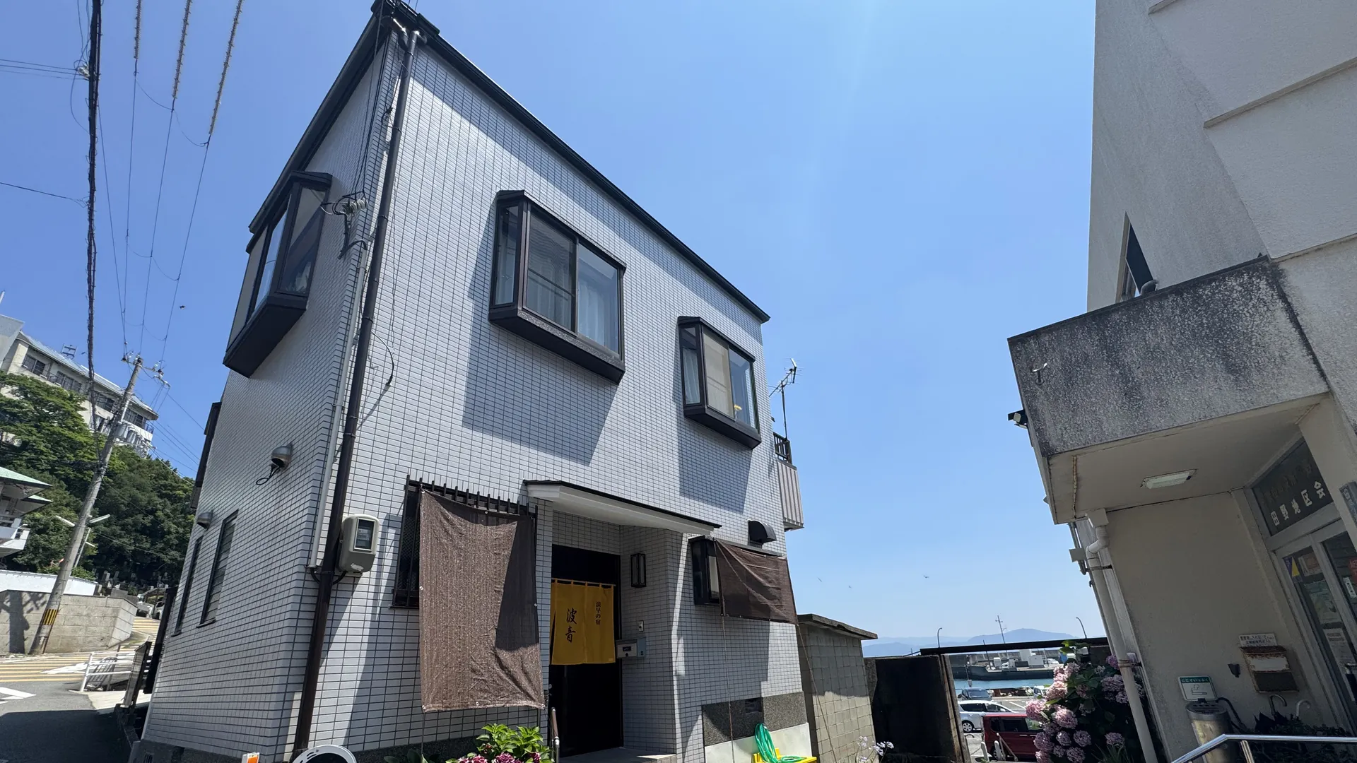 白い壁の2階建ての浪早の宿 波音の外観