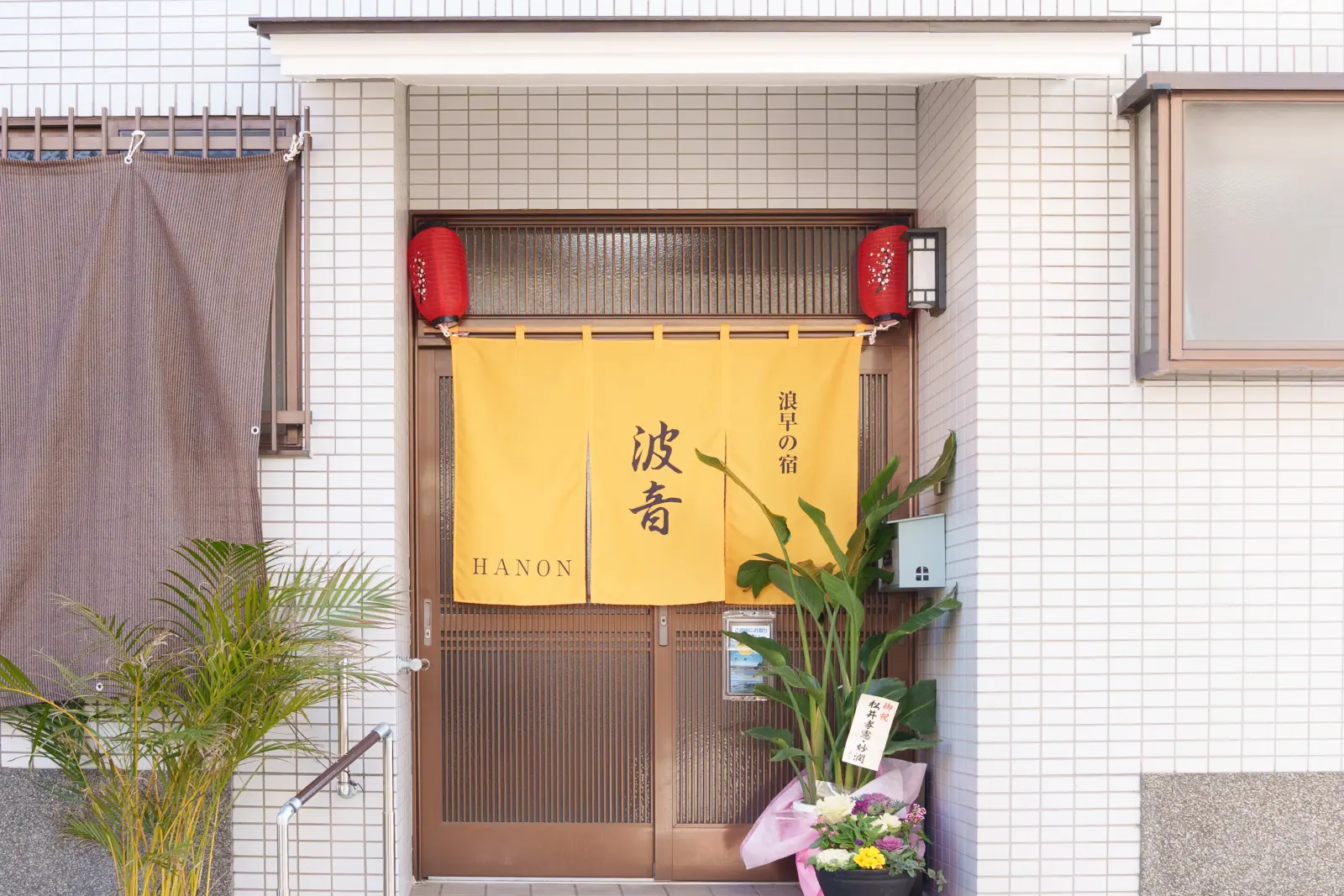 黄色い暖簾が掛かった浪早の宿 波音の玄関